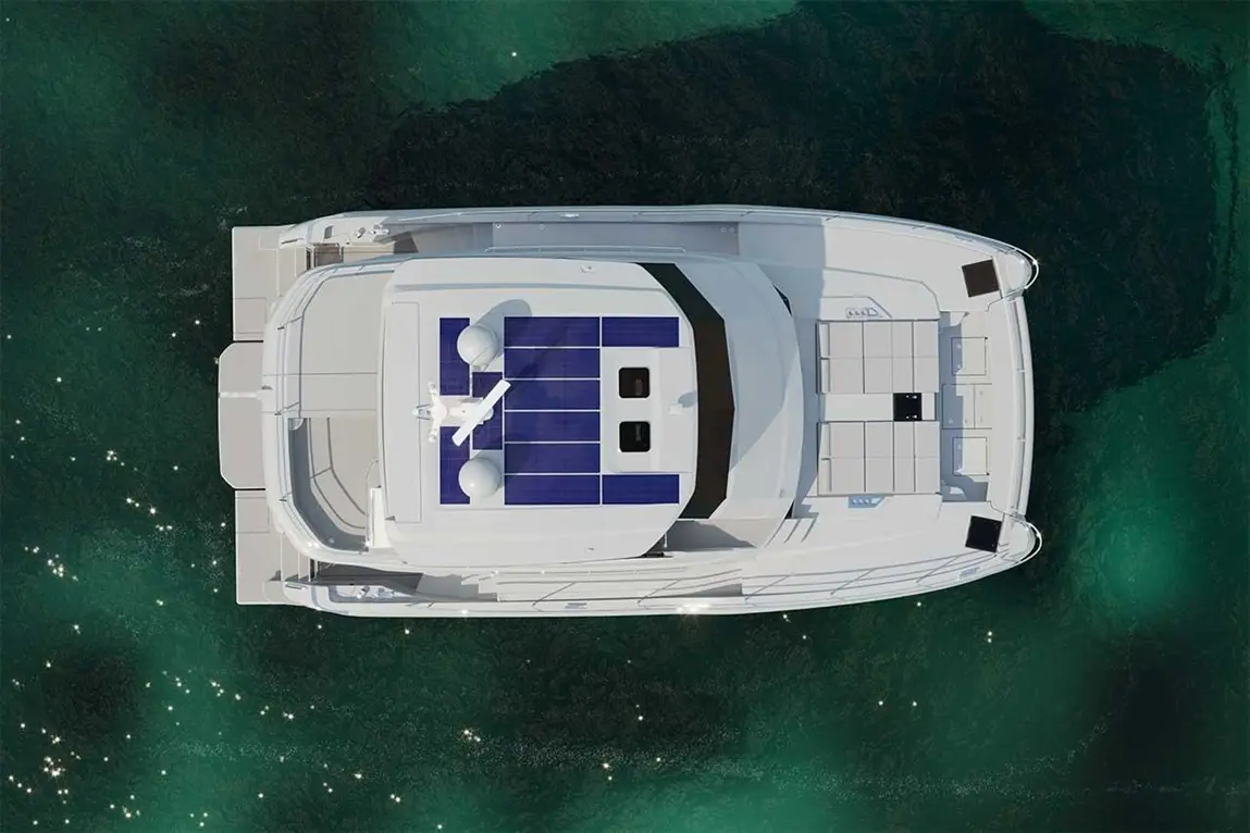Aerial view of a modern yacht with solar panels, surrounded by green water, showcasing outdoor seating and navigation equipment.